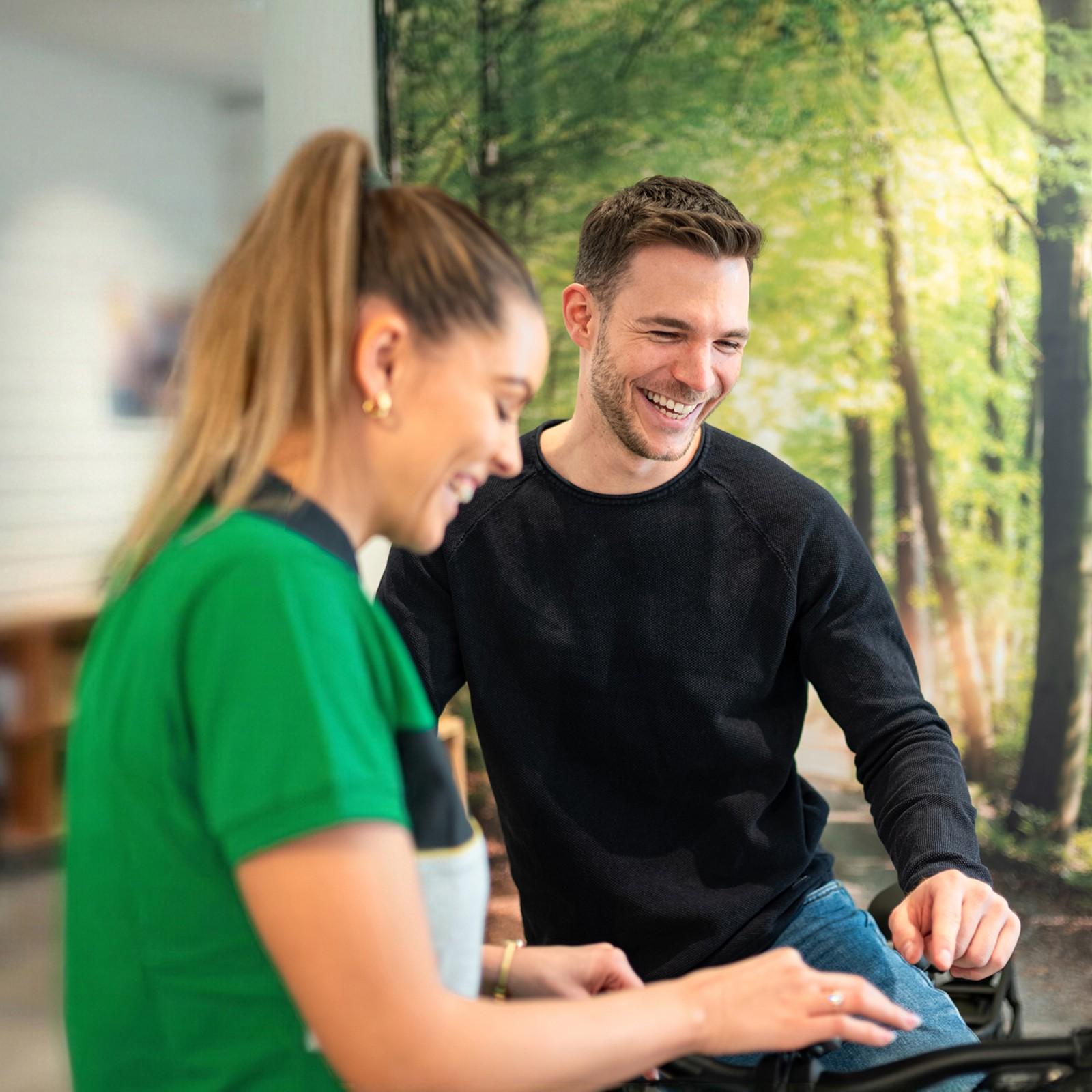 Eine e-motion Mitarbeiterin informiert einen interessierten Kunden über e-Bikes