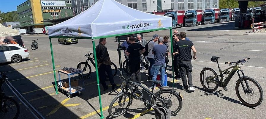 E-Bike Workshop unter Pavillon mit e-motion Logo und Fahrrädern