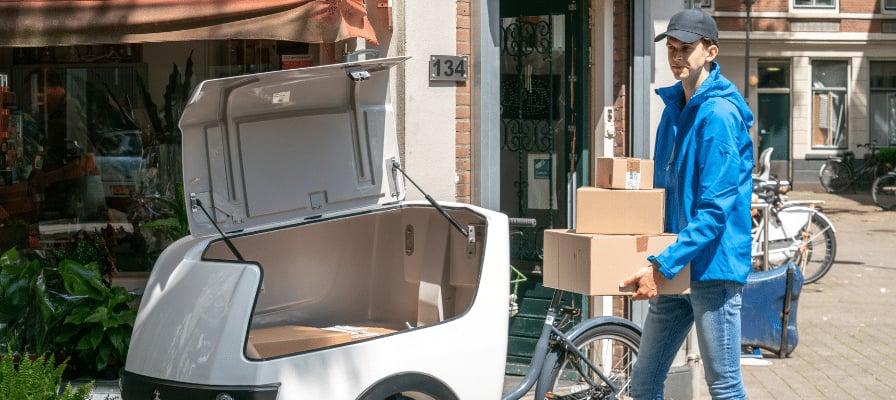 Person liefert Pakete mit Lastenrad in städtischer Umgebung