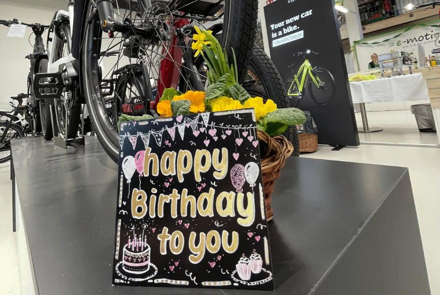 Fahrradgeschäft mit Geburtstagskarte und Blumenarrangement