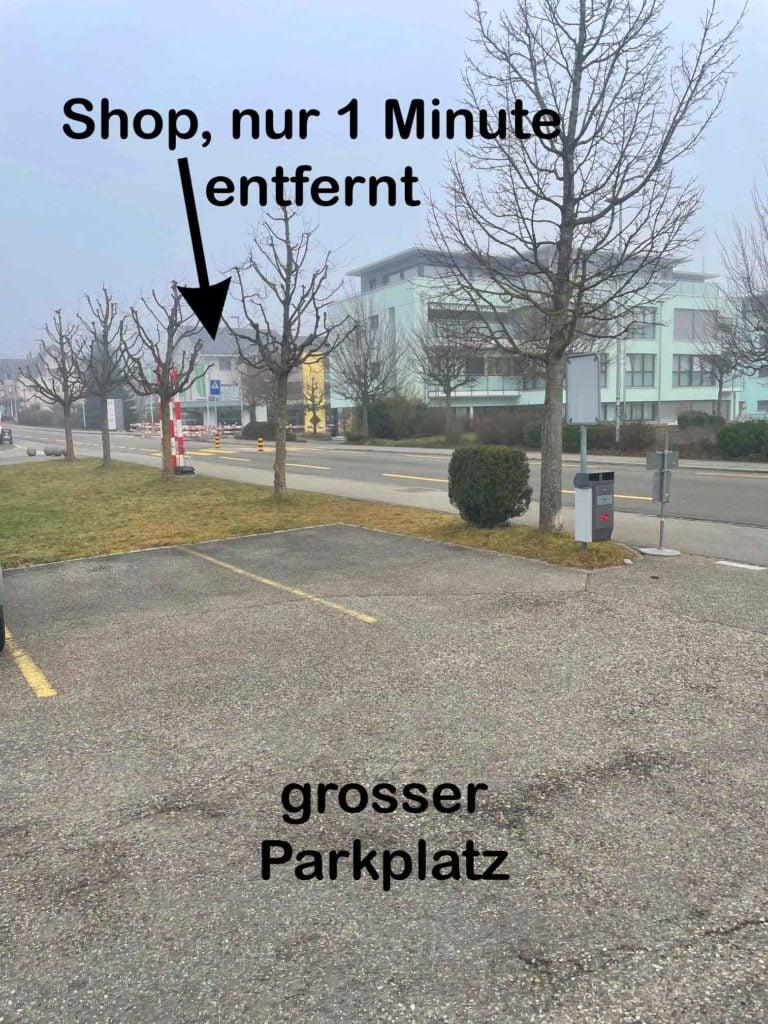 Großer Parkplatz mit Hinweis auf nahegelegenen Shop