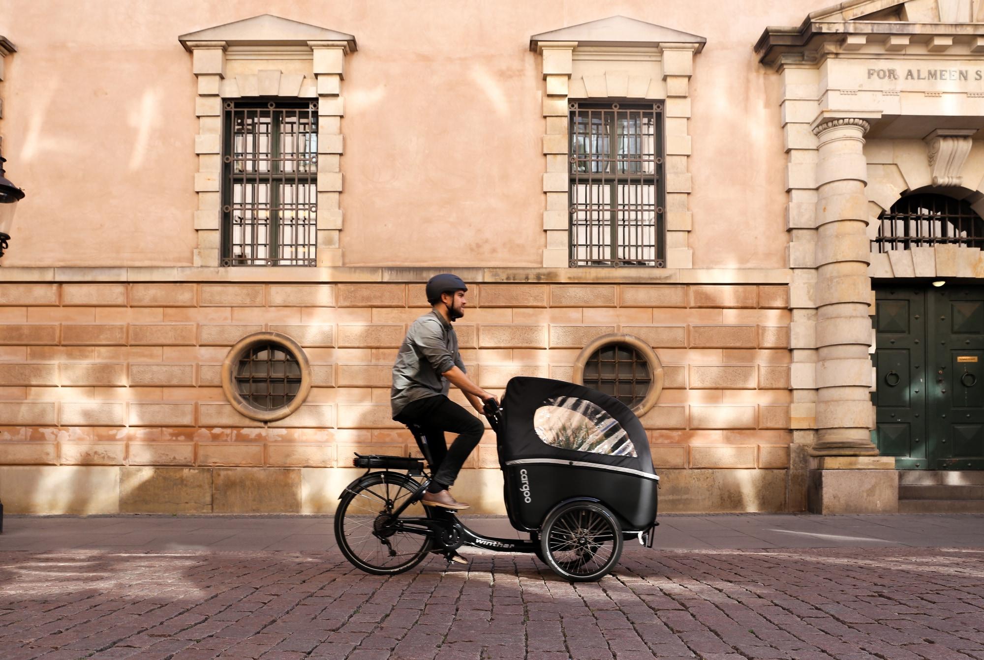 Entdecken Sie das Winther Kangaroo E-Lastenrad. Perfekt für städtische Mobilität vor klassischem, historischem Hint