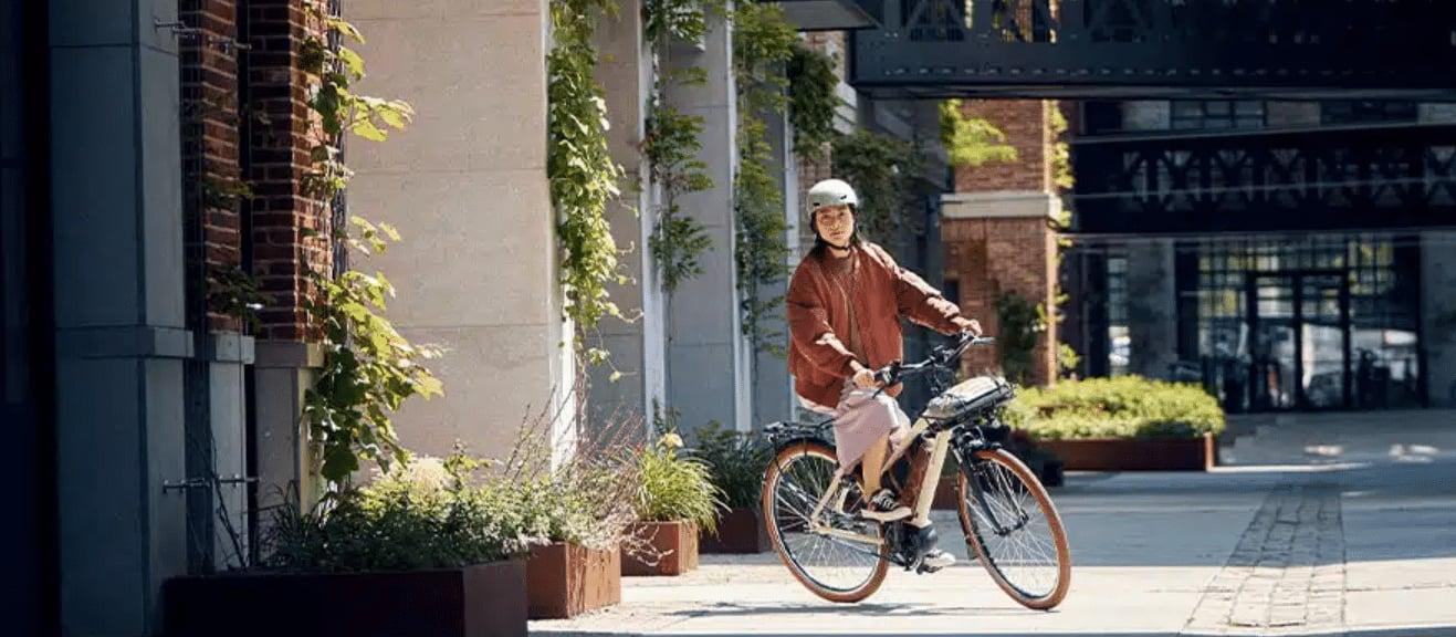 Person fährt E-Bike in urbaner Umgebung mit Helm