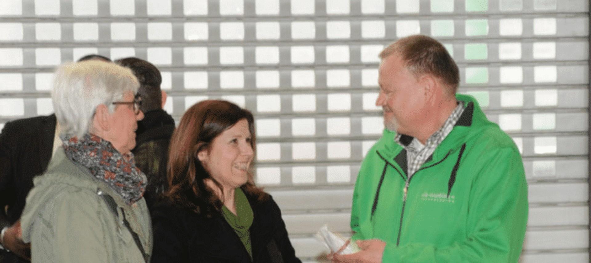 Das Bild zeigt eine Interaktion zwischen mehreren Personen bei der Neueröffnung in Saarbrücken.