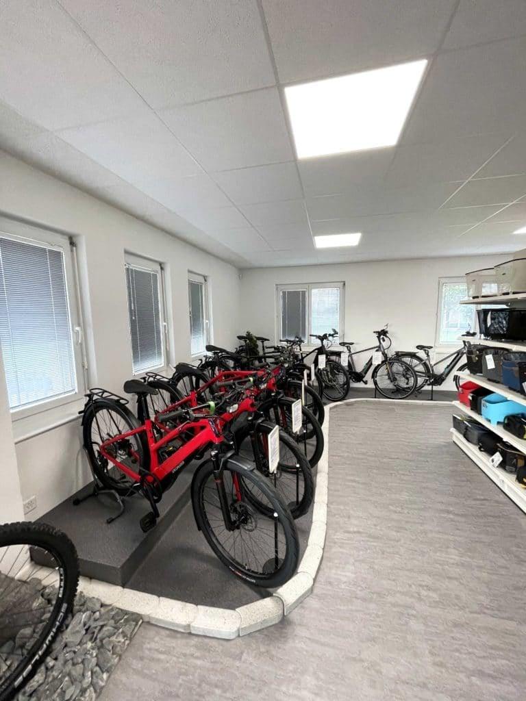 Fahrradgeschäft mit roten Fahrrädern und Zubehör im Ausstellungsraum