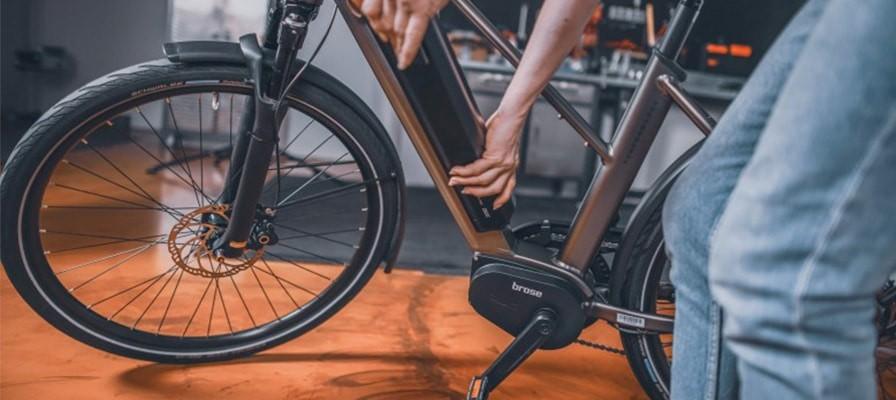 Eine Person entnimmt e-Bike Akku, Brose Remanufacturing
