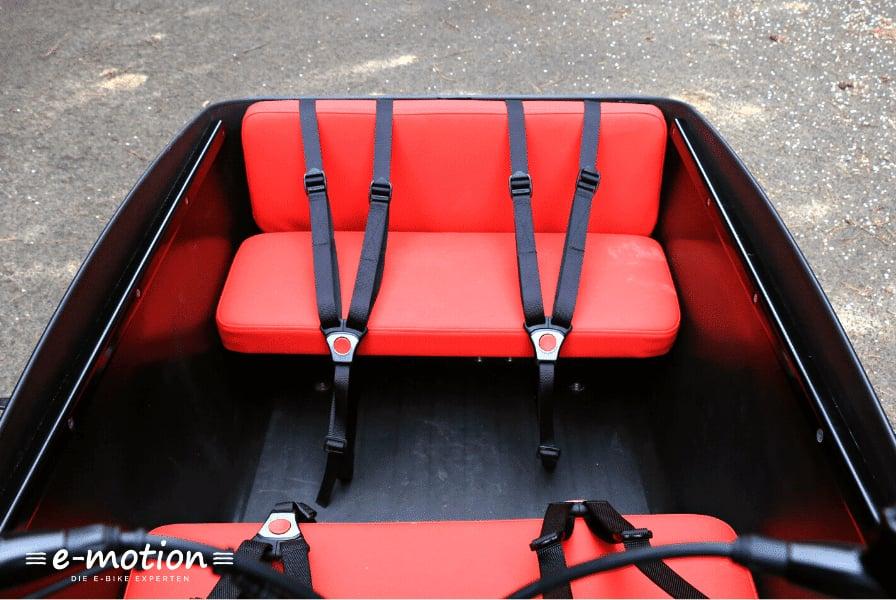 Roter Sitzbereich mit Sicherheitsgurten in einem Lastenrad