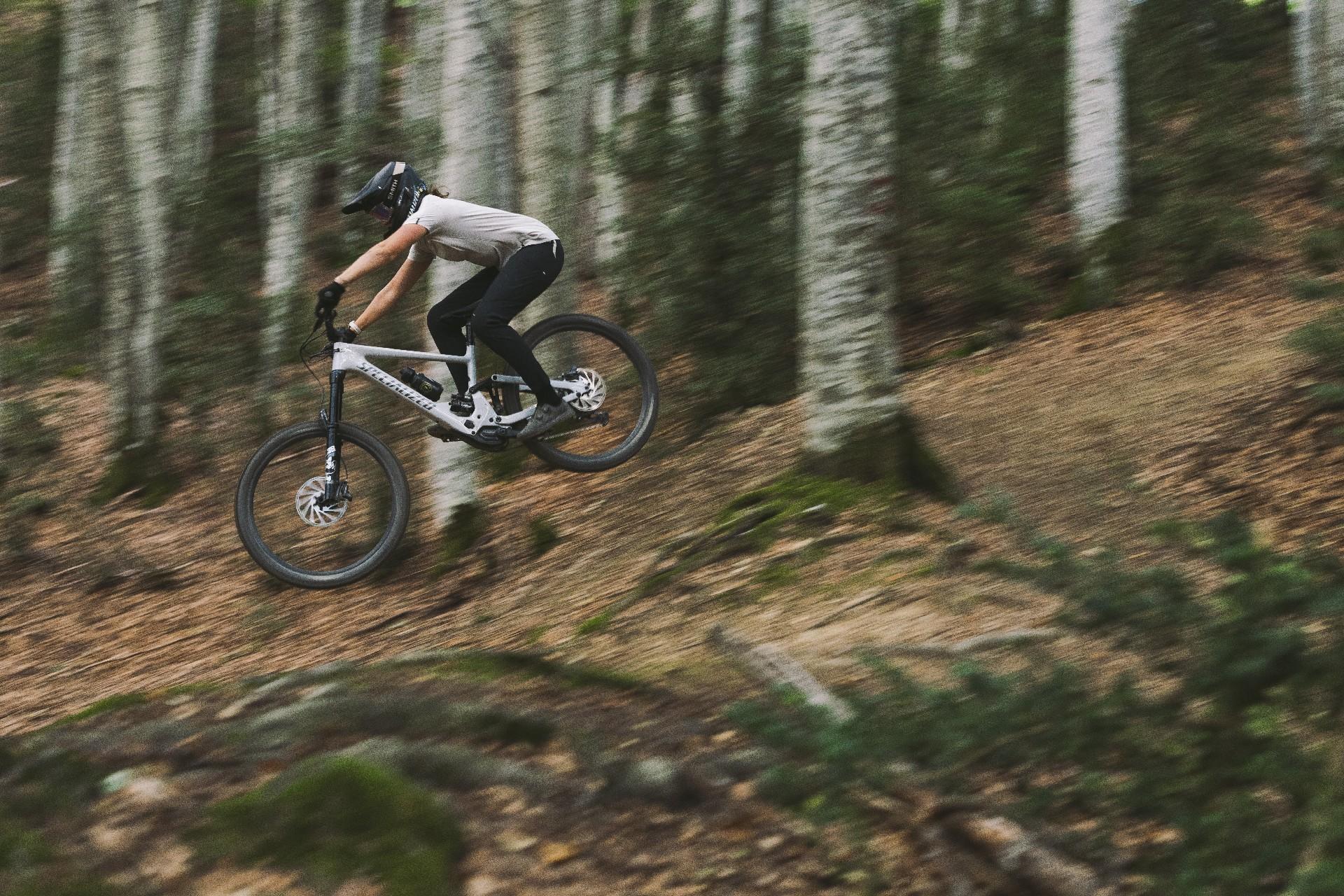 Eine  Person springt mit Specialized Kenevo SL e-MTB im Wald