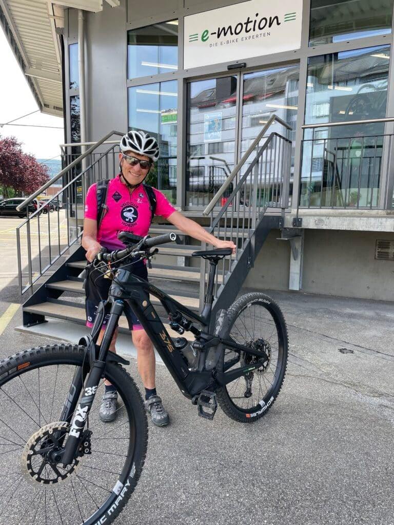 Person mit E-Bike vor einem E-Bike-Geschäft