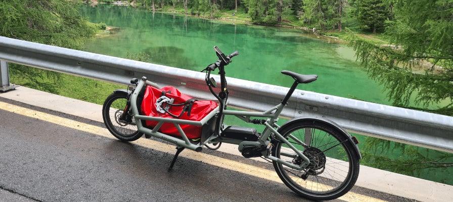 Lastenfahrrad an malerischem Seeufer mit grünem Wasser