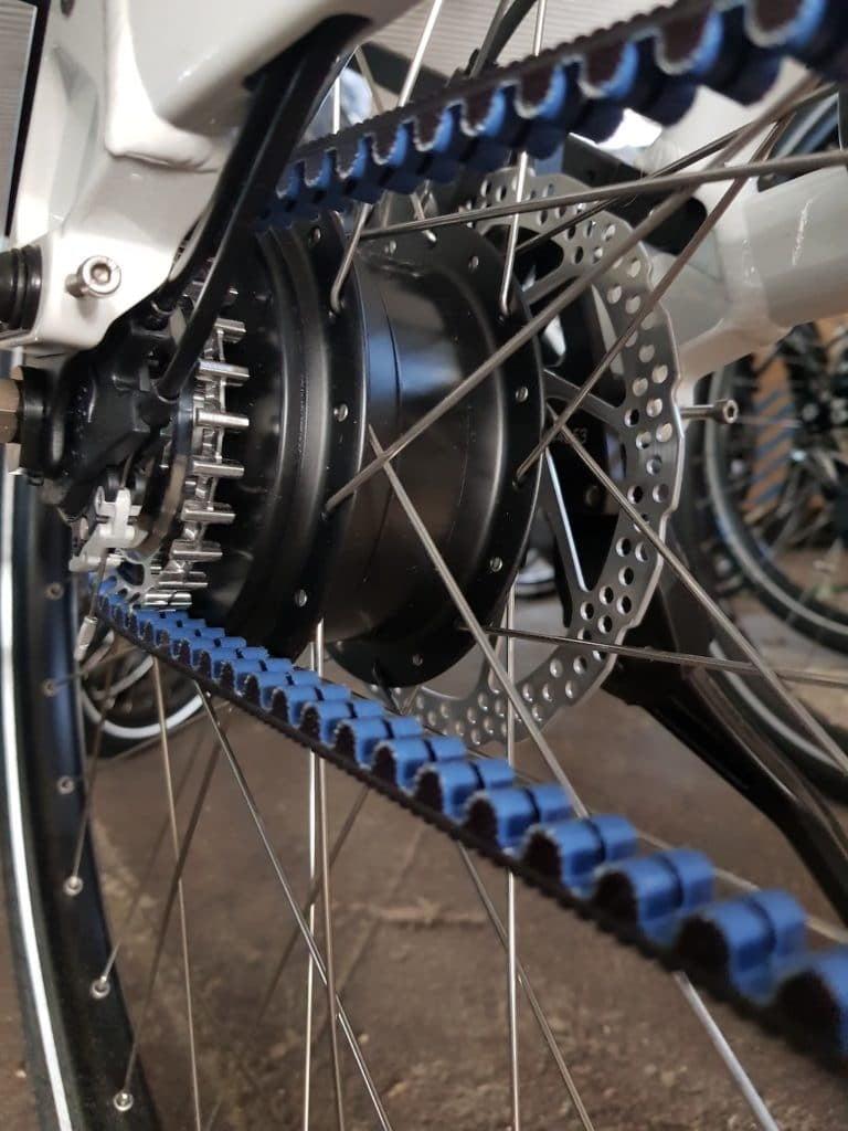 Nahaufnahme eines Fahrrad-Hinterrads mit blauer Zahnriemenantrieb