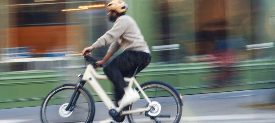 Person fährt Riese & Müller E-Bike in urbaner Umgebung