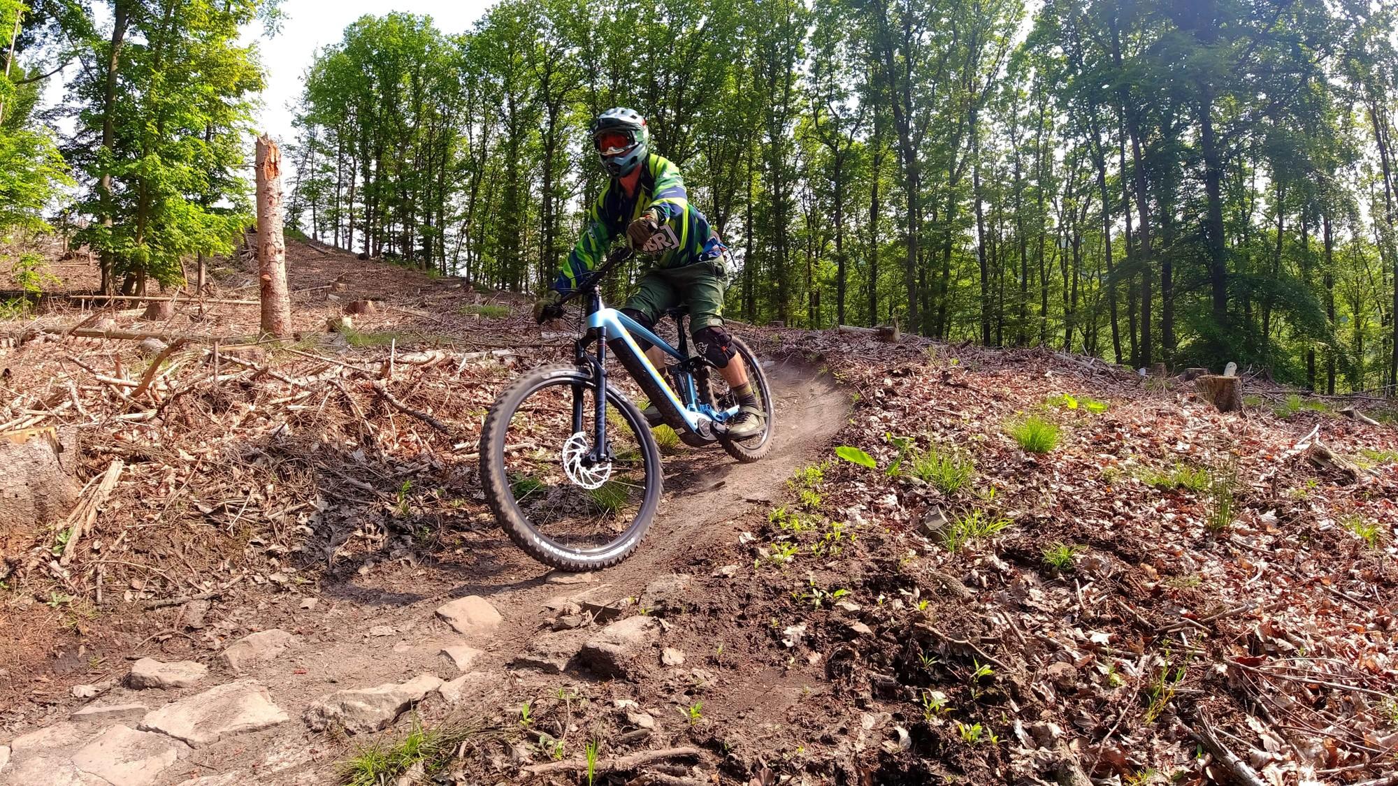 Das Bild zeigt einen Mountainbiker, der mit einem Corratec E-Bike auf einem naturbelassenen Trail unterwegs ist.