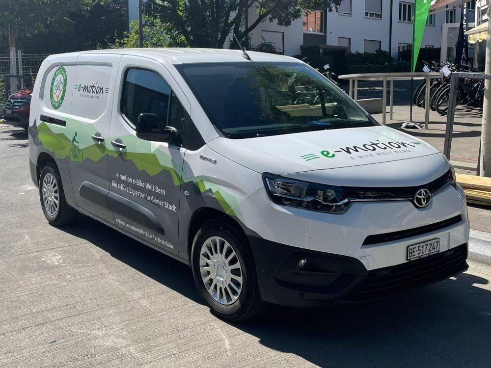 Weißer Toyota Elektro-Van mit e-motion Branding in städtischer Umgebung