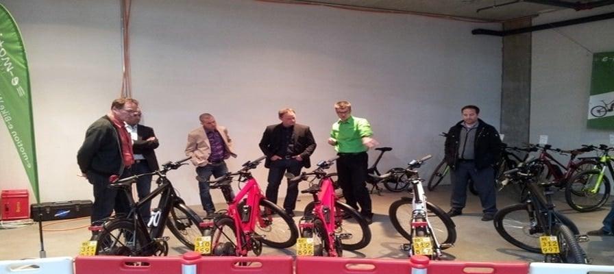 Personengruppe betrachtet E-Bikes in einer Ausstellung