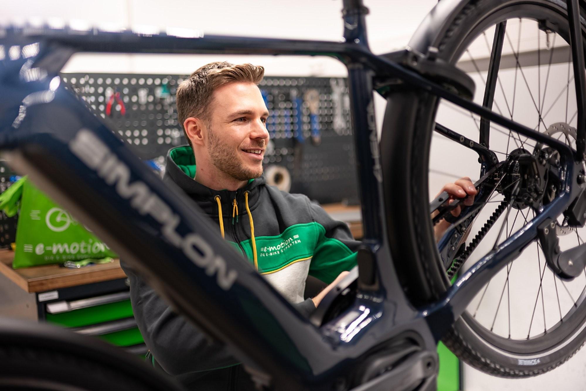 Ein Mitarbeiter steht hinter einem Simplon e-Bike in der Werkstatt