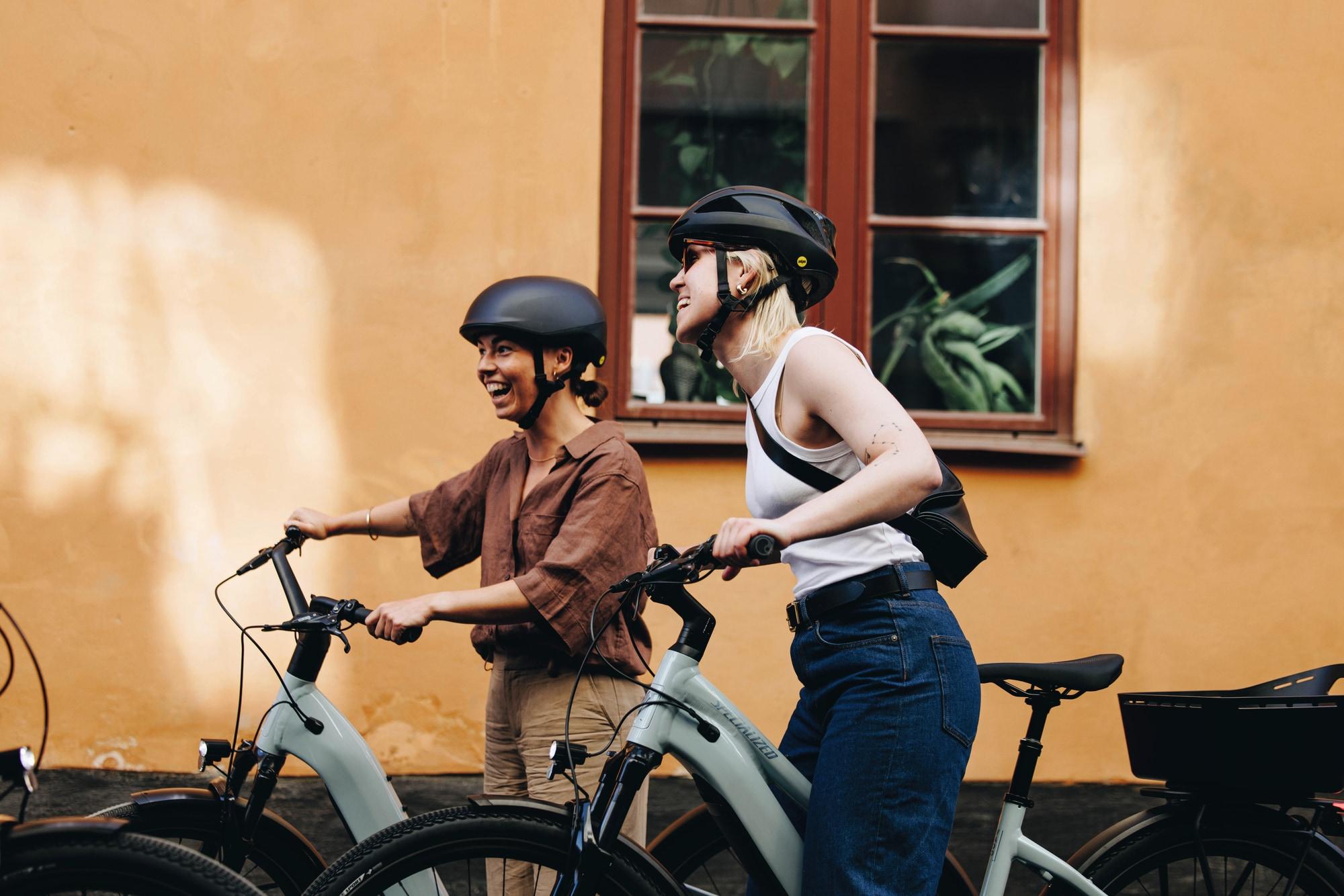 Zwei Personen genießen eine Fahrradtour auf Specialized Como E-Bikes, ideal für urbane Ausflüge mit Stil und Komfor