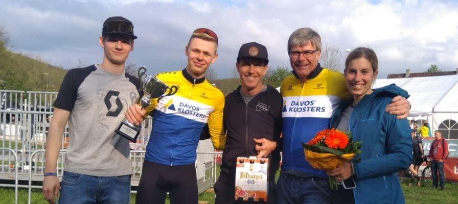 Gruppe von Personen mit Pokal und Blumen bei Outdoor-Event