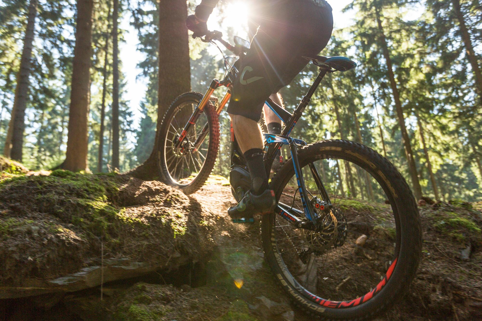 Das Bild zeigt ein E-Mountainbike (eMTB), das einen steilen Anstieg in einem bewaldeten Gebiet meistert.