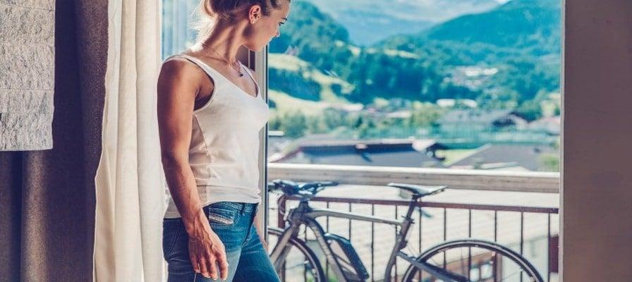 Frau betrachtet E-Bike auf Balkon mit Bergblick