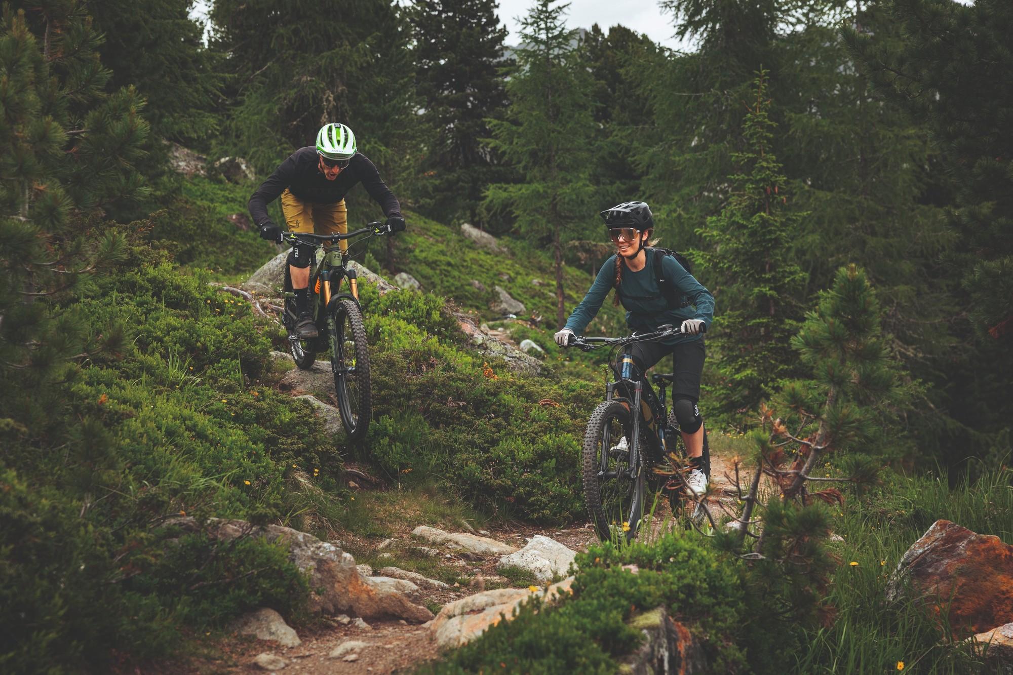 Das Bild zeigt zwei Radfahrer, die auf einem unebenen, naturbelassenen Pfad fahren.