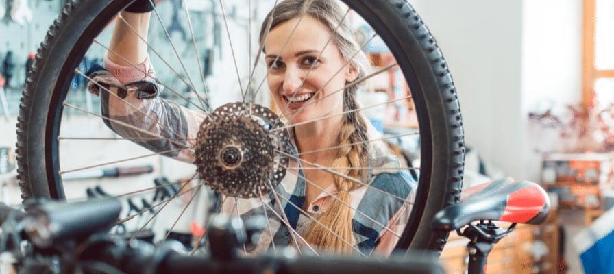 Frau überprüft Fahrradreifen in Werkstatt