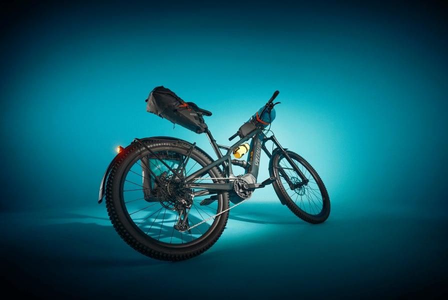 Mountainbike mit Gepäcktaschen auf blauem Hintergrund