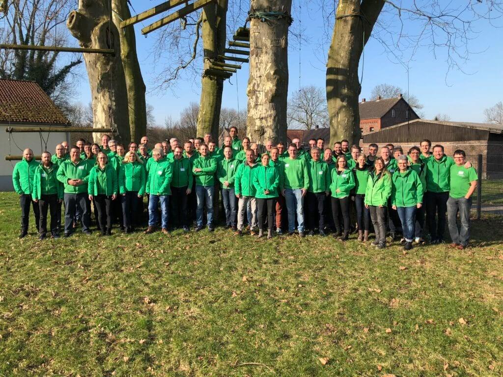 Gruppenfoto von Menschen in grünen Jacken im Freien