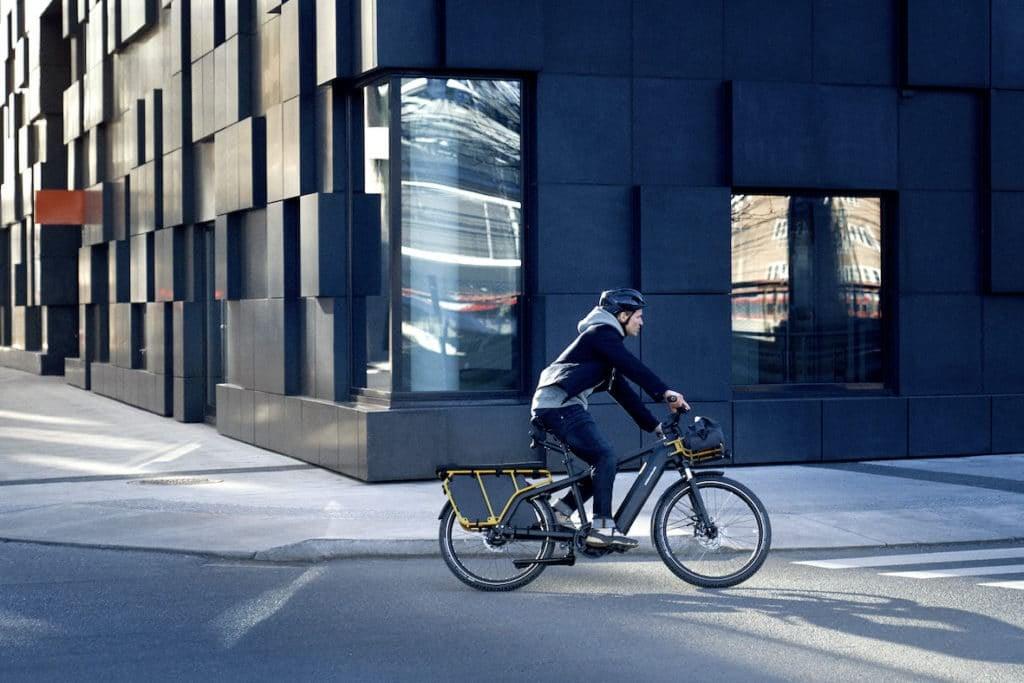 Person fährt Riese & Müller Multicharger E-Bike in urbaner Umgebung