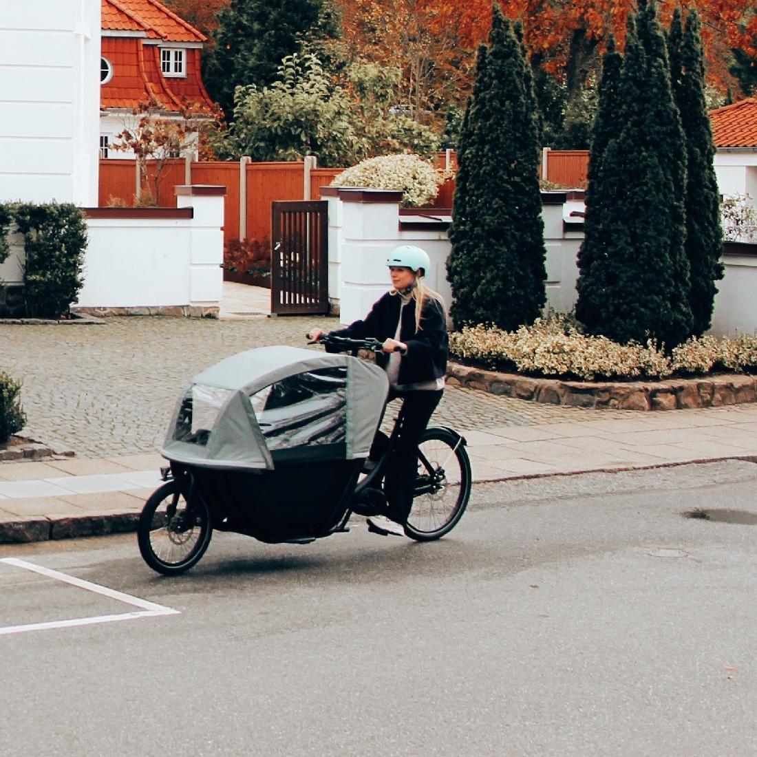 Eine Frau fährt mit dem neuen Winther W2 Lasten e-Bike durch ein Wohngebiet.