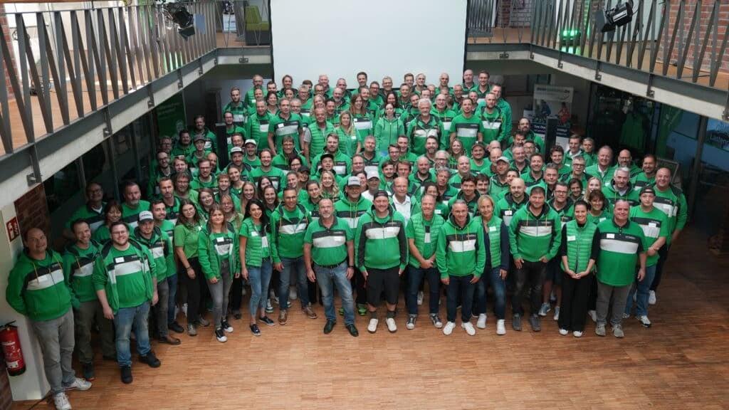 Gruppenfoto von Personen in grünen Shirts in einem Innenraum