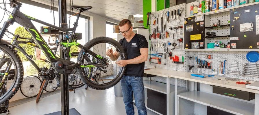 Fahrradmechaniker bei der Arbeit in moderner Werkstatt