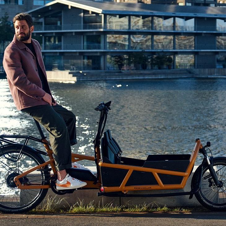 Ein Mann sitzt auf Riese & Müller Load4 75 direkt am Wasser