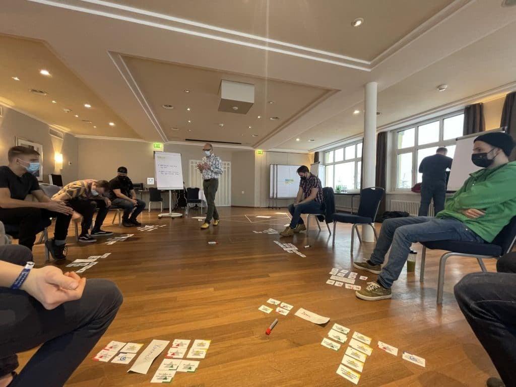 Workshop in Konferenzraum mit Teilnehmern und Karten auf dem Boden