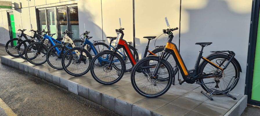 Mehrere E-Bikes verschiedener Marken auf einem Gehweg ausgestellt