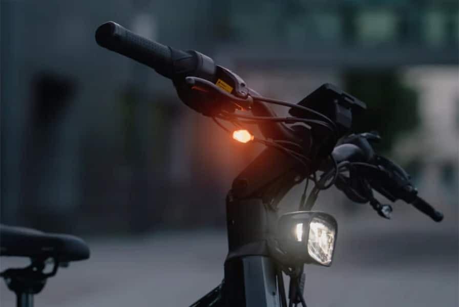 Nahaufnahme eines E-Bike-Lenkers mit Beleuchtung bei Dämmerung