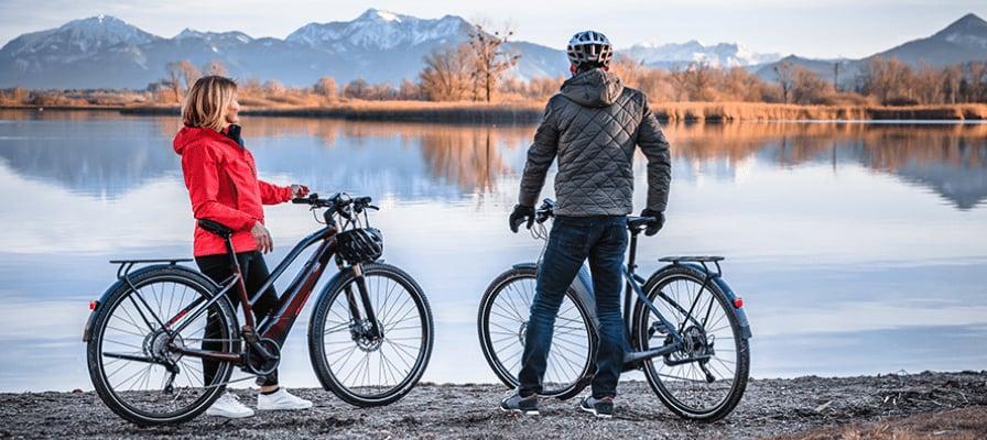 Zwei Personen mit E-Bikes vor malerischer Bergkulisse