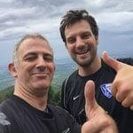 Zwei Männer lächeln und zeigen Daumen hoch im Freien