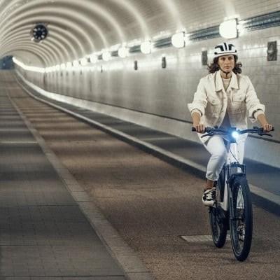 Person fährt Riese & Müller Nevo3 E-Bike durch beleuchteten Tunnel