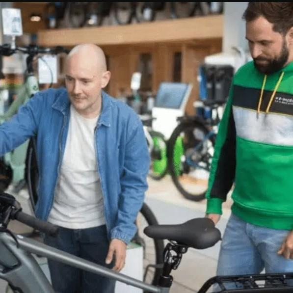 Zwei Männer betrachten ein E-Bike in einem Fahrradgeschäft