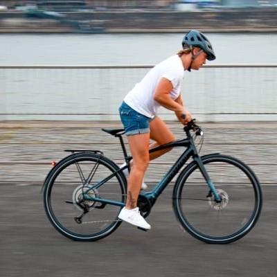 Person fährt Specialized Vado SL E-Bike entlang eines Flusses