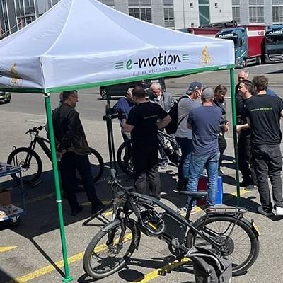 E-Bike Workshop unter Pavillon mit e-motion Logo und Fahrrädern