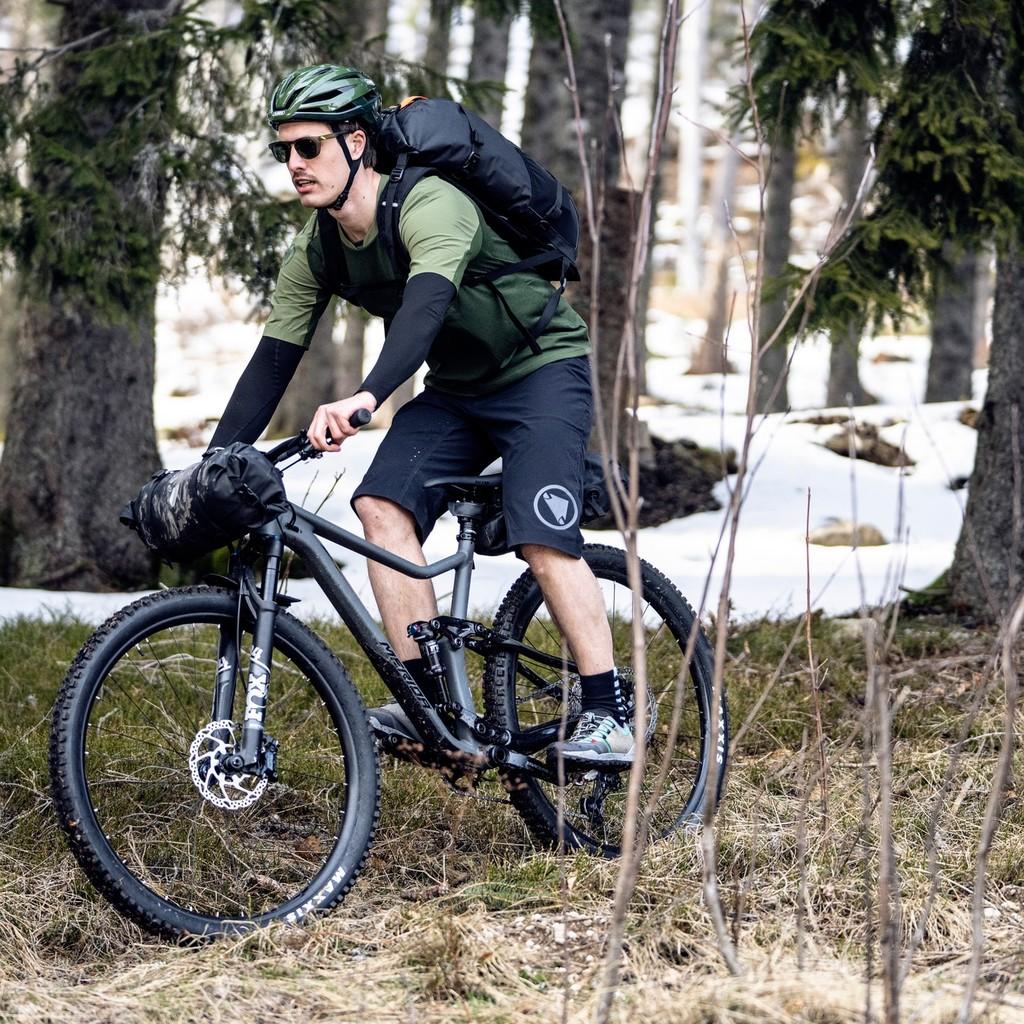 Ein Radfahrer genießt eine Offroad-Fahrt im schneebedeckten Wald auf einem Mountainbike. Perfekt für Abenteuerlusti