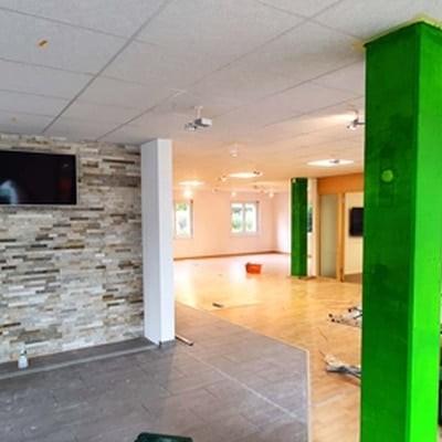 Innenraum eines renovierten Geschäfts mit grüner Säule und Steinwand