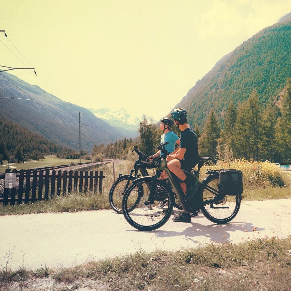 Zwei Personen stehen vor einem Bahnübergang mit Cannondale Tesoro e-Bikes