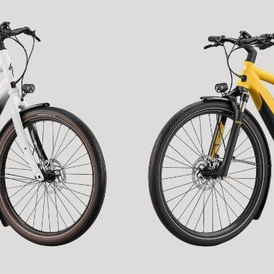Zwei moderne E-Bikes in Weiß und Gelb auf grauem Hintergrund
