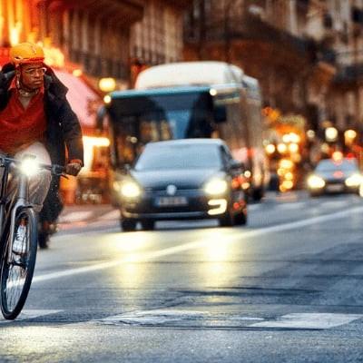Mann fährt bei Nacht mit E-Bike durch belebte Stadtstraße