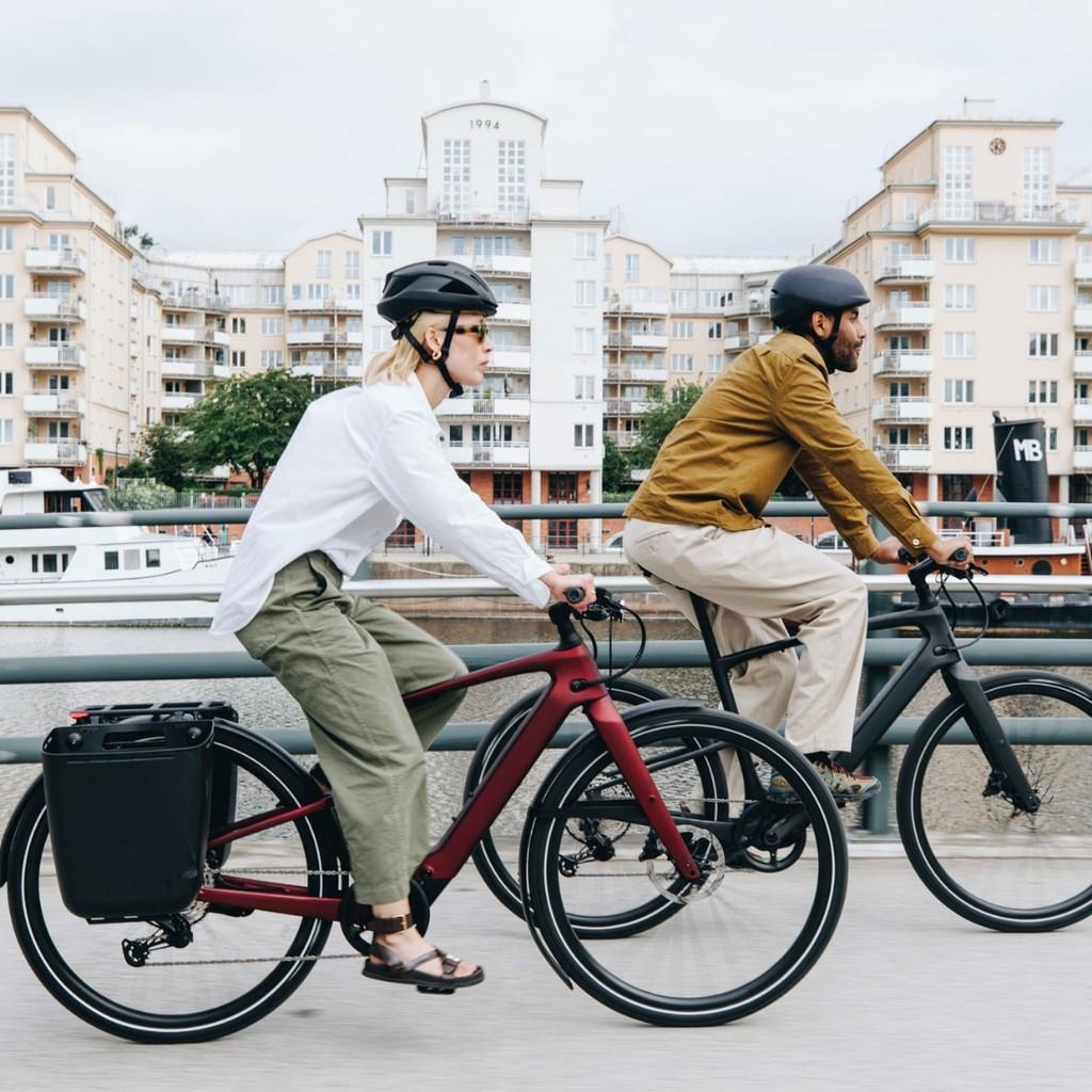 Zwei Personen auf Specialized Vado SL E-Bikes in der Stadt, perfekt für urbane Mobilität und stilvolles Pendeln.