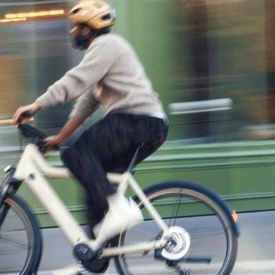 Person fährt Riese & Müller E-Bike in urbaner Umgebung