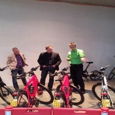 Personengruppe betrachtet E-Bikes in einer Ausstellung
